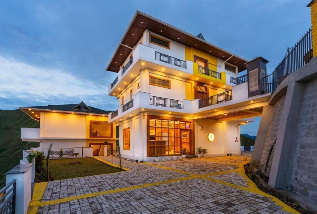 A multi-story hotel with a modern design, featuring balconies and a well-lit entrance.