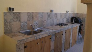 A kitchen with a sink, stove, and cabinets.