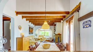 A spacious dining area with a granite table, wooden chairs, and a hanging light fixture. - Sunny Family Villa, Calpe (Calpe)