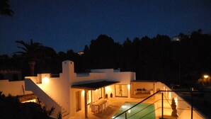 Une maison moderne dotée d’une piscine, d’un patio couvert et d’un escalier menant à l’étage supérieur.