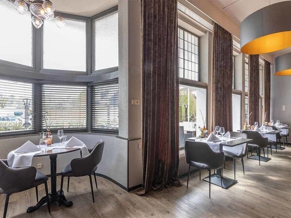 Enjoy formal dining in this elegantly set room with tables, chairs, and fine china.