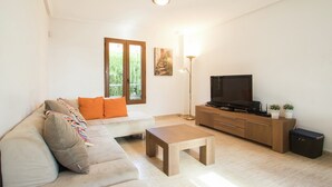 A living room with a sofa, a coffee table, a TV, and a cabinet.