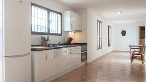 A kitchen with white cabinets, a stove, and a window.