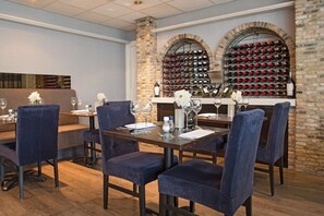 Enjoy a formal dining experience with a long table set for guests, accompanied by a wine rack and elegant table settings.