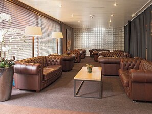 Relax in a stylish lounge area with leather sofas and a central coffee table.