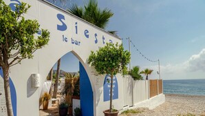 En strandbar kaldet "Siete le bar" med en træterrasse og plantekasser.