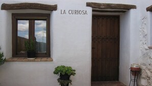 A rustic building with a wooden door and a window with a potted plant. - Holiday Home in Laroya near centre (Laroya)