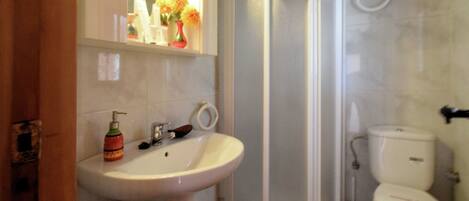 A bathroom with a sink, toilet, and shower.
