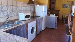 Uma cozinha compacta com máquina de lavar, micro-ondas e frigorífico.