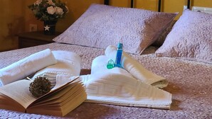 Uma cama bem arrumada com almofadas, um livro e um objeto decorativo.