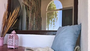 A cozy seating area with a bench, a cushion, a lantern, and a book. - Cottage in La Joya with Pool and Garden (La Joya)