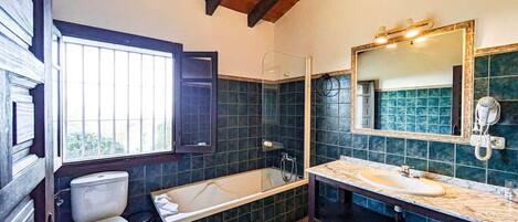 A bathroom with a toilet, bathtub, and sink.