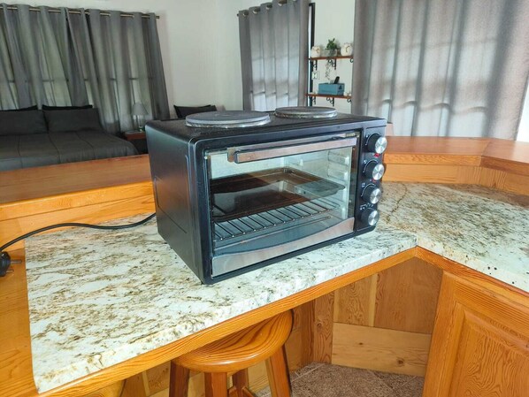 A kitchen with a built-in toaster oven on a wooden countertop.