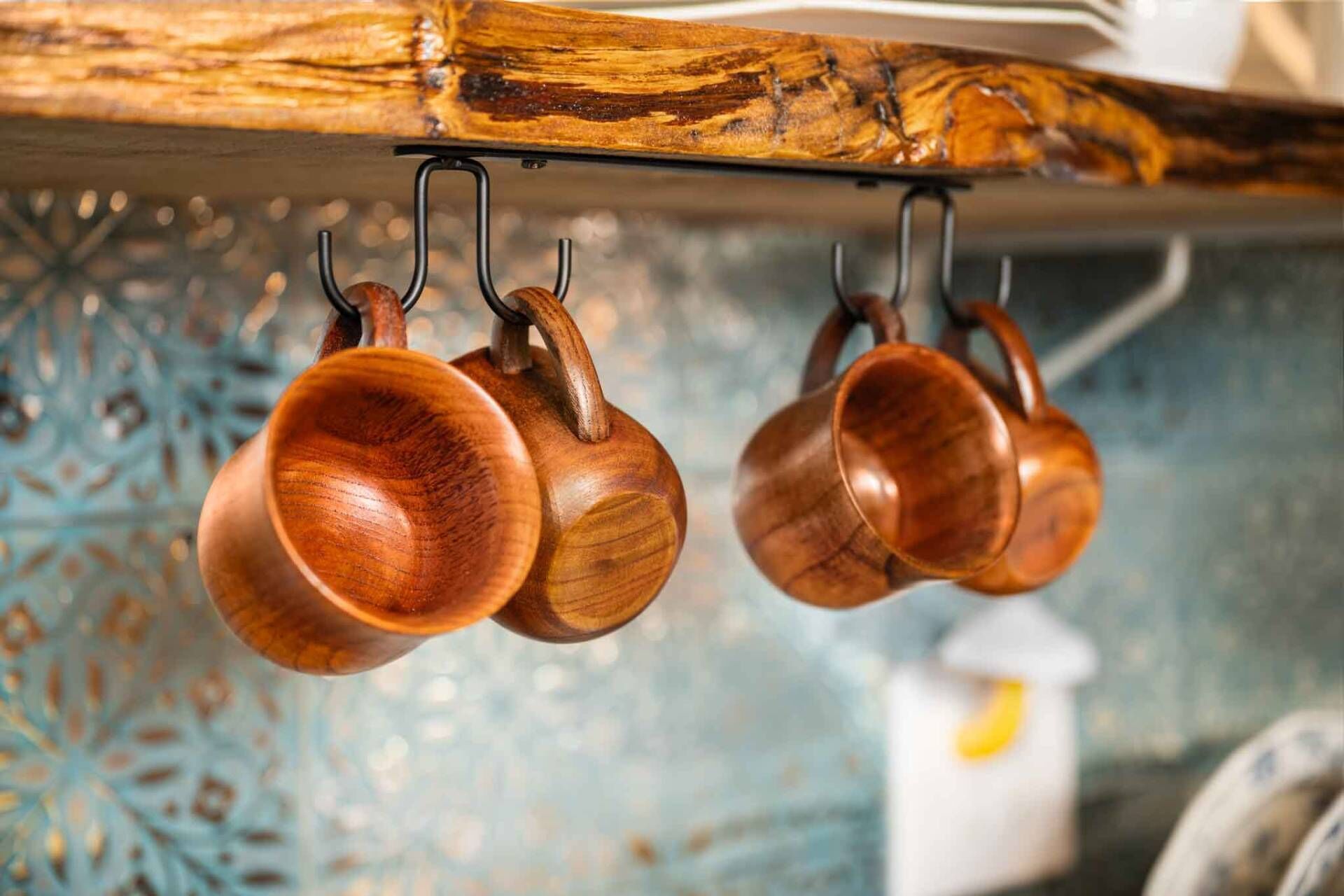 Wooden kitchen utensils hanging from a rack.