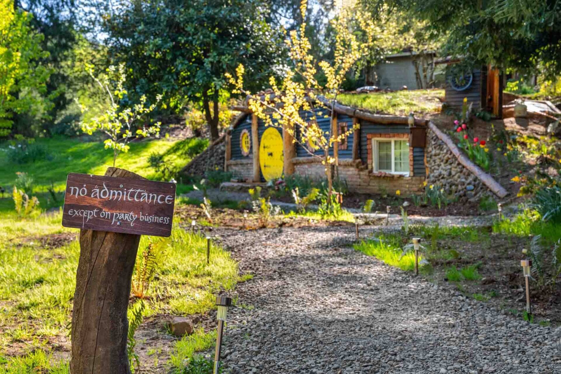 A rustic house with a wooden door and a sign indicating no admittance except for party business.