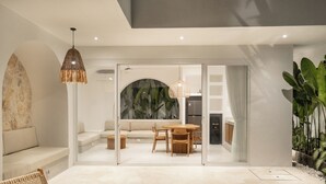 Een modern interieur met een zwembad, een eethoek met een tafel en stoelen, een bank en een hanglamp.