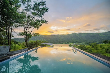 Una piscina al aire libre, sillones reclinables de piscina