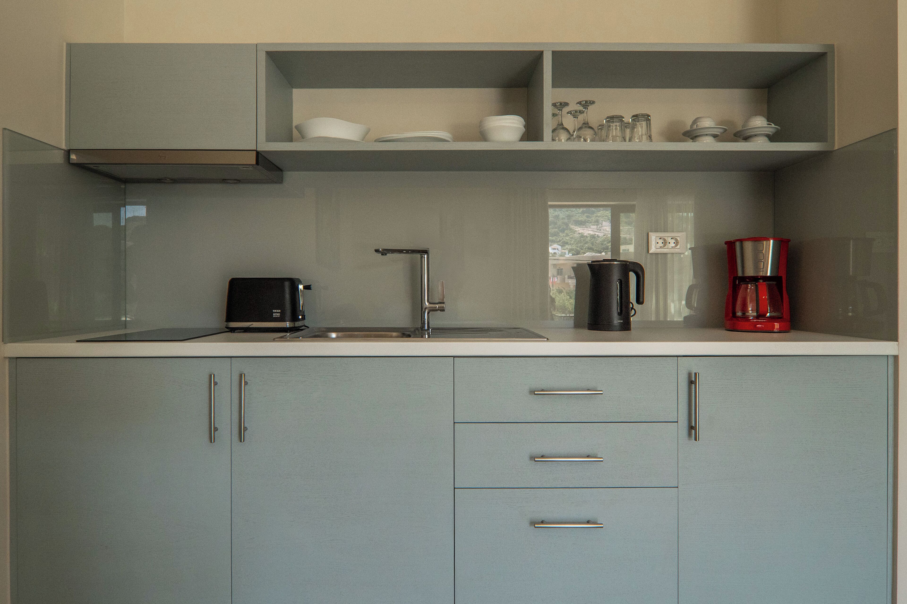 A modern kitchen with a built-in sink, a coffee maker, and a toaster.