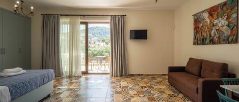 A room with a bed, a sofa, a TV, and a painting.