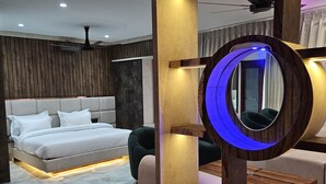 A modern bedroom with a bed, a circular mirror, and a built-in seating area. - Gurugram Resort Mussoorie (Mussoorie)