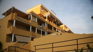 A multi-story hotel with balconies, a staircase, and a sign reading "Cascadas de la Marina".