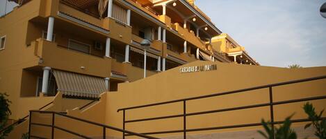 A multi-story hotel with balconies, a staircase, and a sign reading "Cascadas de la Marina".