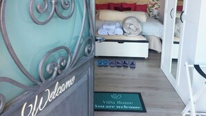 A hotel room with a bed, a wardrobe, and a decorative metal gate with the word "Welcome". - Panoramic cottage 100 mt from the main square view Taormina and Calabria (Castelmola)