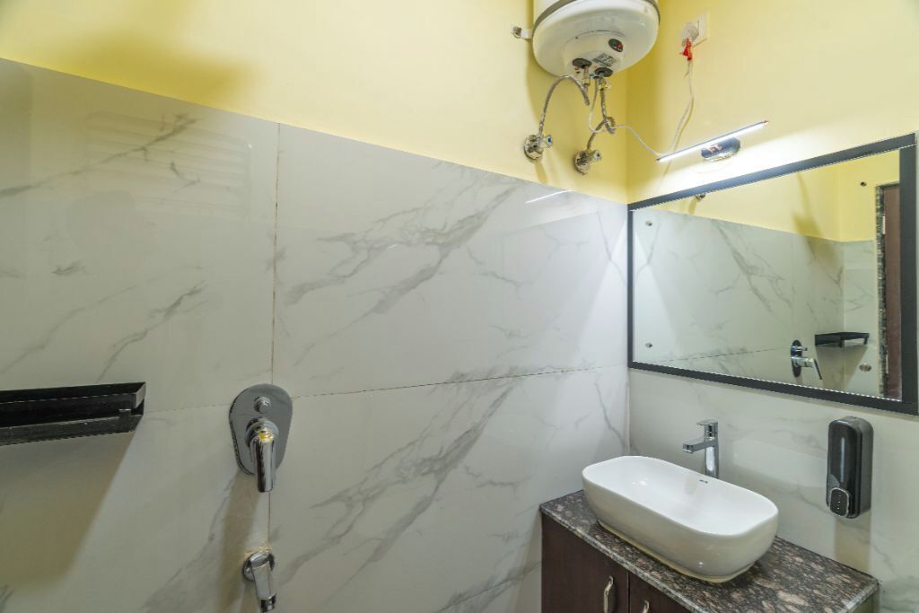 A bathroom with a marble sink, a mirror, and a shower.