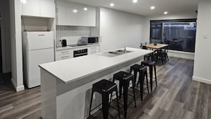 Una cucina moderna con isola centrale, sgabelli da bar e zona pranzo con vista.