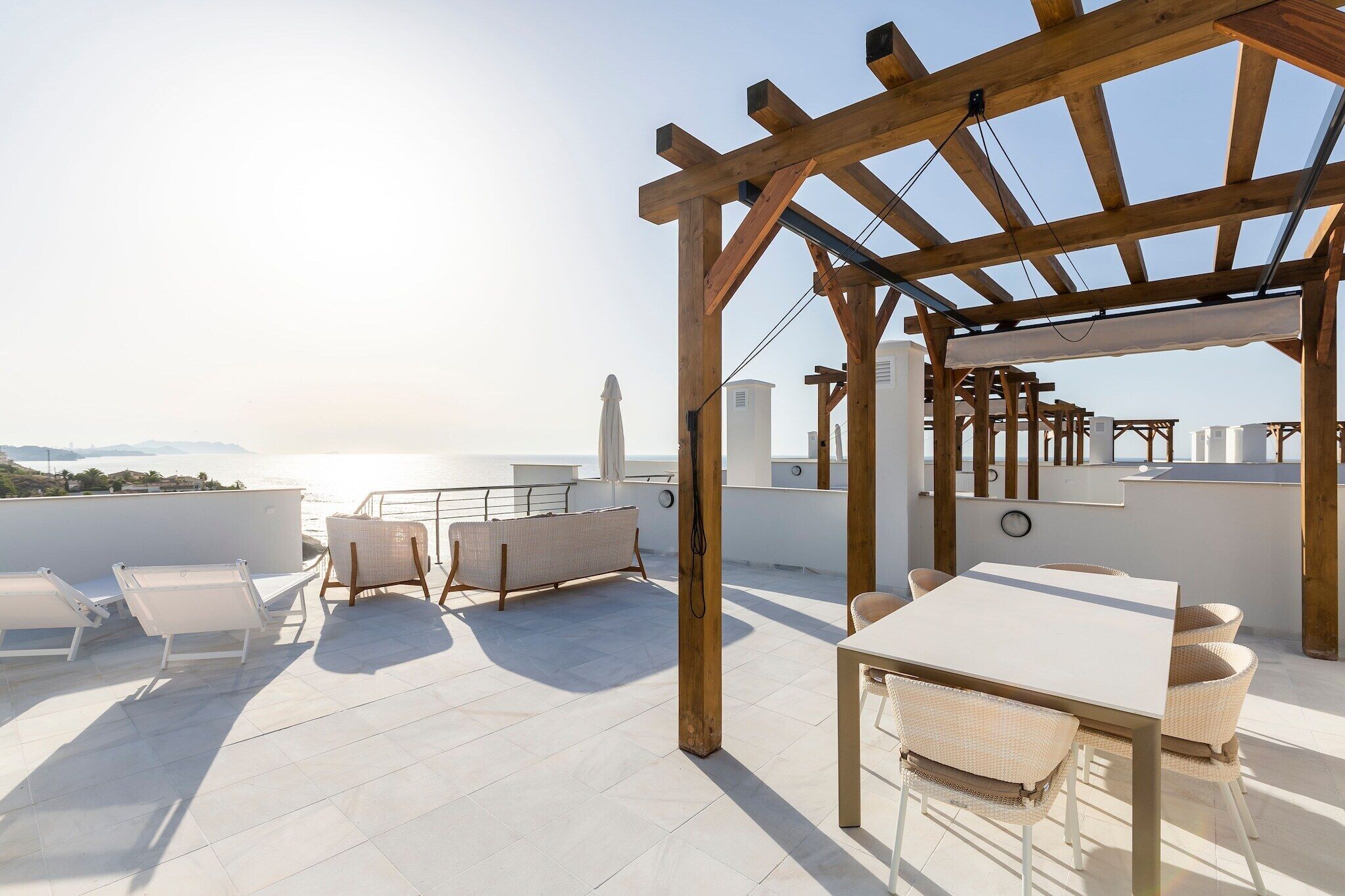 Une terrasse sur le toit, dotée d’une pergola, d’un espace salon et d’une table.