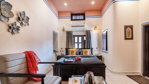 Une chambre d’hôtel avec un lit, un canapé, une table basse et un bureau.