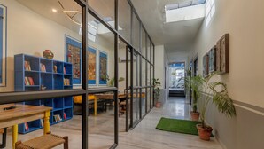 Une bibliothèque moderne avec des étagères, une table en bois et un banc.