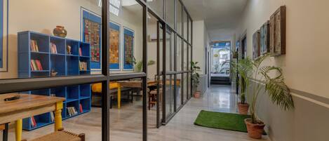 A modern library with bookshelves, a wooden table, and a bench.
