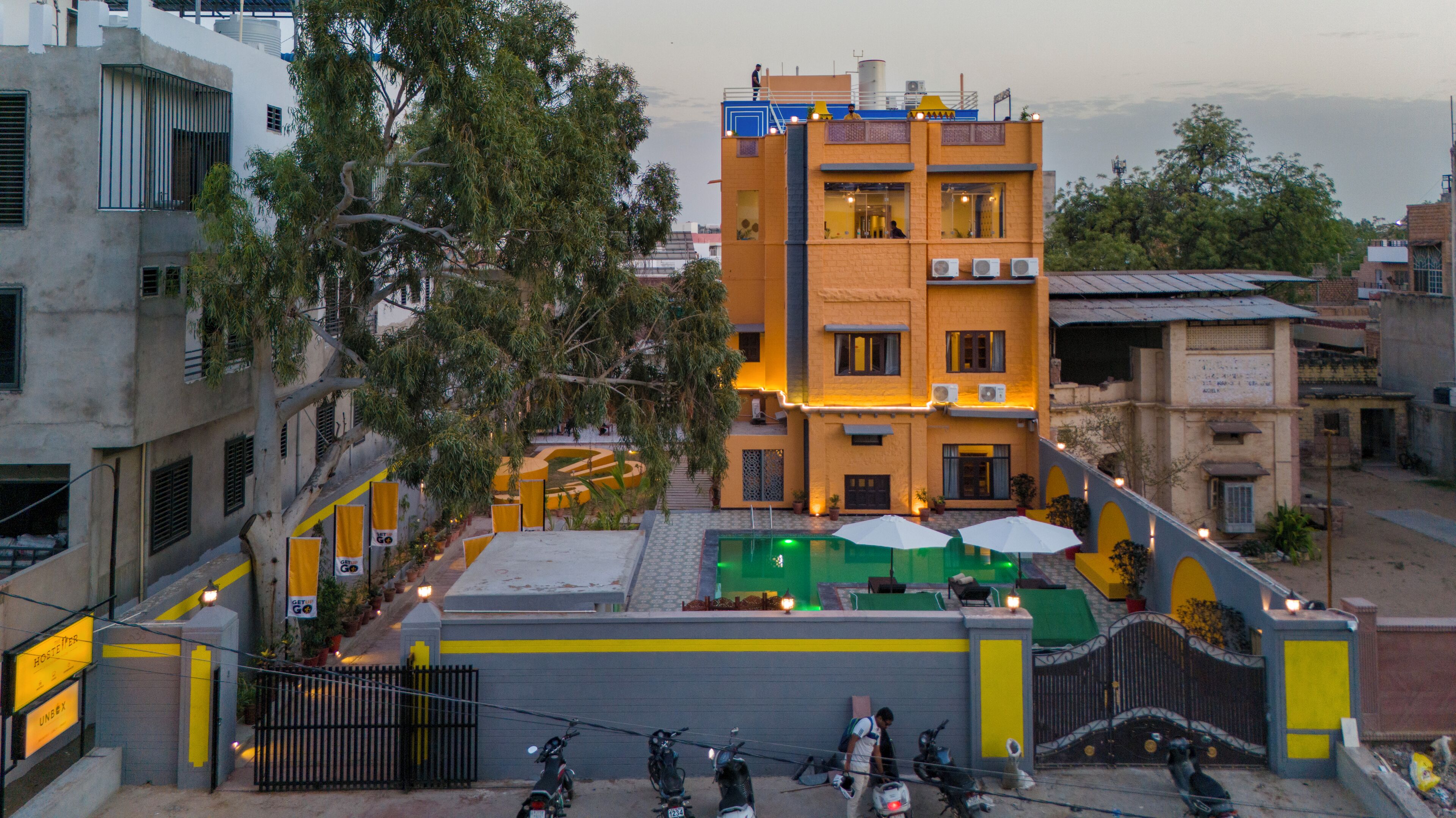 A multi-story building with a courtyard, outdoor seating, and a gated entrance.