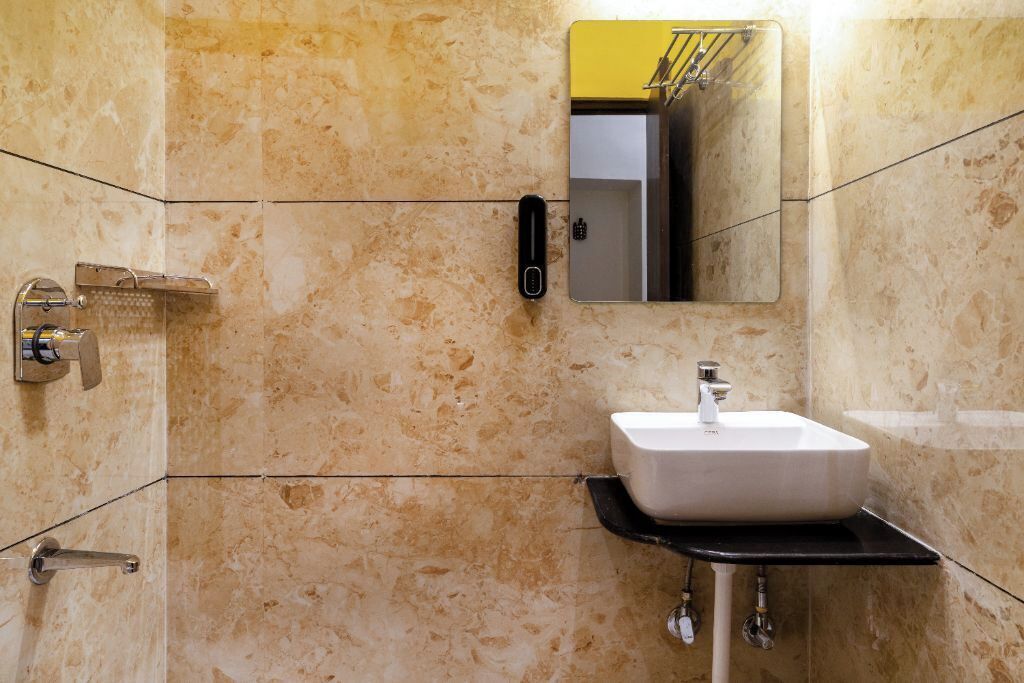 A bathroom with a white sink, a mirror, and a shower.