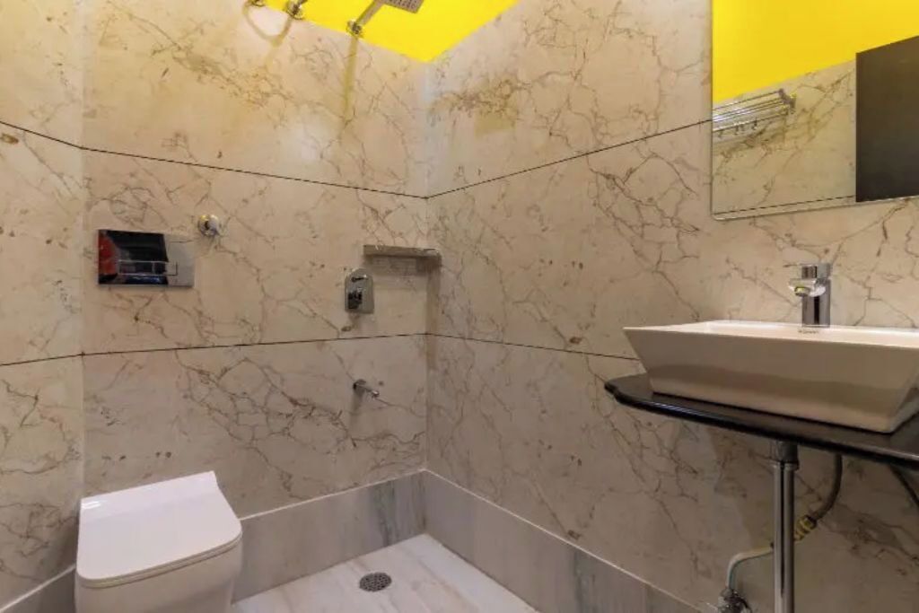 Een badkamer met toilet, wastafel, spiegel en douche.
