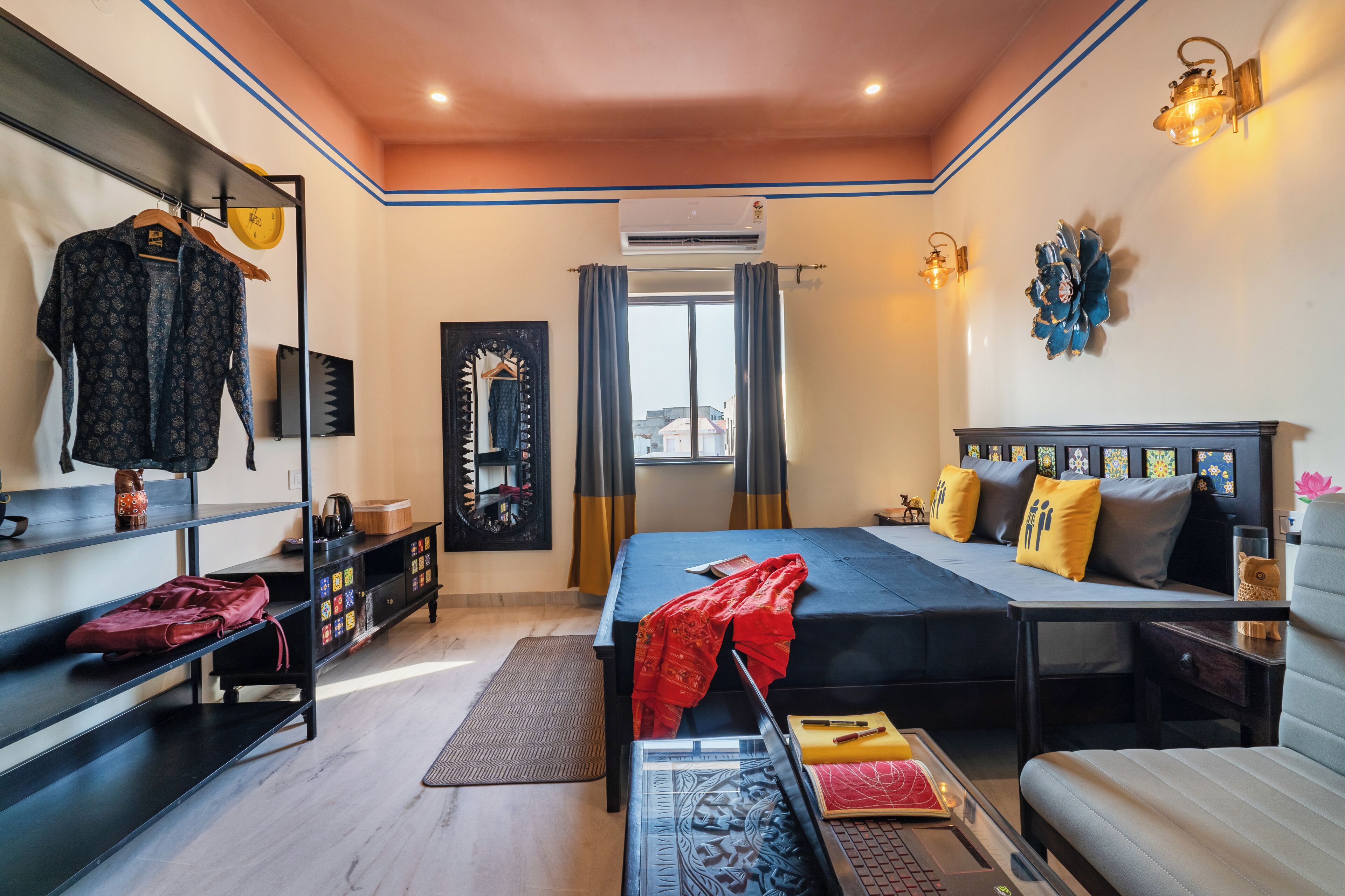 A bedroom with a bed, bedside tables, a wardrobe, a mirror, and a window with curtains.