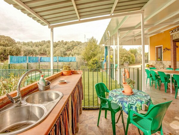 Enjoy dining al fresco in this charming outdoor space, complete with a kitchen counter and dining table.