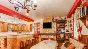 Une cuisine chaleureuse avec des meubles en bois, un dosseret carrelé et un îlot central doté de tabourets.