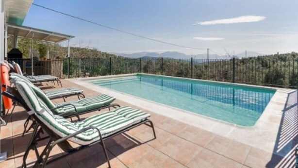 Une piscine avec des chaises longues et une vue sur les montagnes.