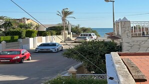 A coastal street with parked cars, a clear sky, and a view of the sea. - Apartment near Sea Beach Walk to Center (Valencia)