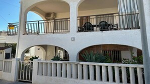 A two-story building with a balcony on the upper floor, a gated entrance, and a number '9' sign. - Apartment near Sea Beach Walk to Center (Valencia)