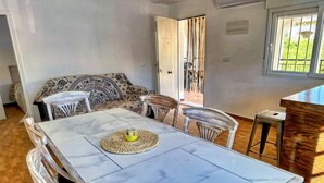 A dining area with a marble table, clear chairs, a woven placemat, and a glass pitcher. - Apartment near Sea Beach Walk to Center (Valencia)
