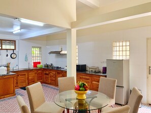 Enjoy cooking in this well-equipped kitchen with a central island, glass table, and modern appliances.