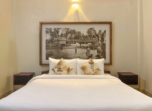 Relax in a serene space with a large bed, two bedside tables, and a framed photograph above.