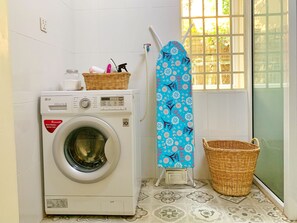 Convenient laundry facilities with a washing machine, drying rack, and storage for your essentials.