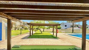 A covered outdoor area with a pool, green artificial turf, and a pergola structure. - Penthouse in Denia with Private Terrace (Denia)