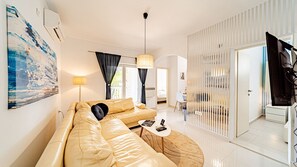 A modern living room with a leather sofa, a coffee table, and a large painting on the wall. - Villa Soldo by Villas Guide (Hodilje)