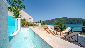 A swimming pool with lounge chairs and a view of a lake and mountains. - Villa Soldo by Villas Guide (Hodilje)