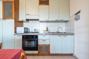 Kühlschrank, Mikrowelle, Herdplatte, Esstisch